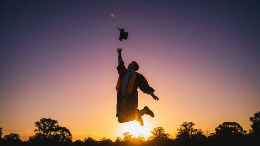 An epic moment of a graduating student in Springvale, Victoria, laughing joyfully with their cap thrown in the air, embodying Springvale graduation photography capturing candid joy, with a blurred backdrop of Springvale Park at sunset, professional, color-graded.