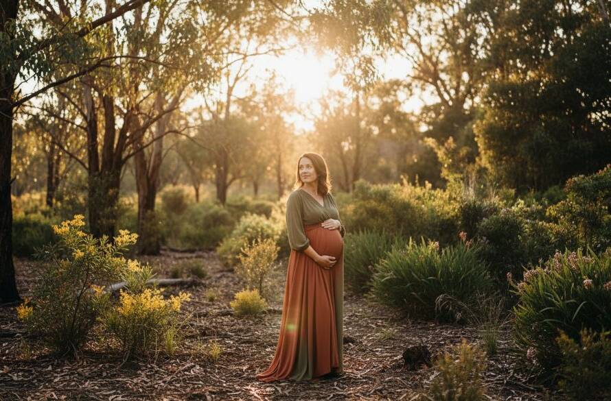 A pregnant woman, in the golden hour light of a Croydon Hills bushland setting, looking serene and radiant, with her hands gently cradling her belly, embodying the beauty of a stunning outdoor maternity photoshoot Croydon Hills Victoria. The sunbeams filter through the eucalyptus trees, creating a warm, ethereal glow around her, captured in an epic, professional photograph.