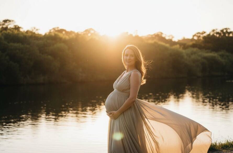 A breathtaking portrait from timeless outdoor maternity photography Bulleen Victoria, featuring a radiant pregnant woman silhouetted against a golden hour sunset over the Yarra River, capturing an epic moment of serene anticipation and natural beauty.