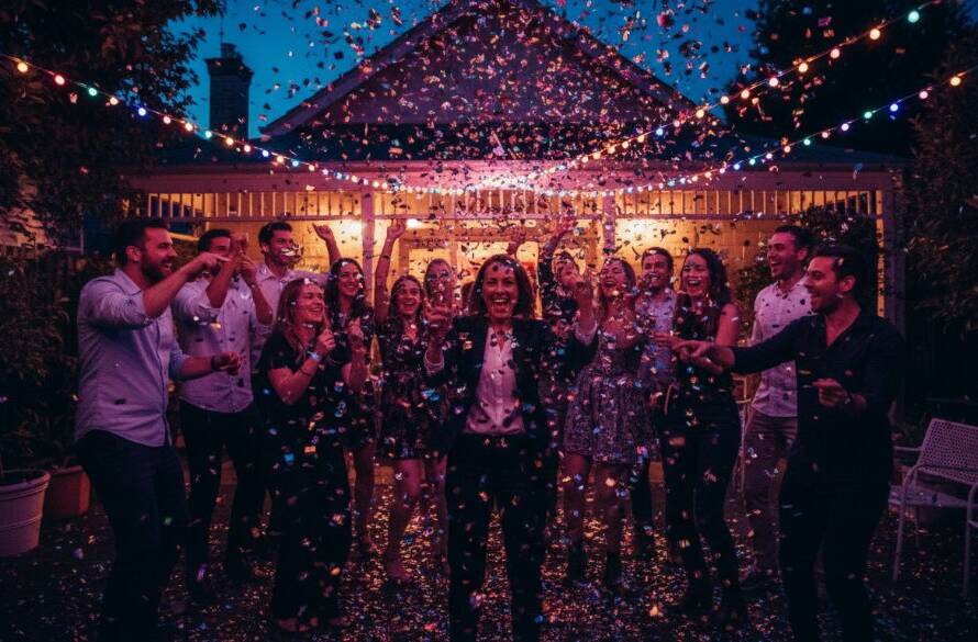 A stunning, low-light shot capturing the pure joy and laughter of guests dancing enthusiastically at a lively celebration in Caulfield South, epitomizing unforgettable candid party photography Caulfield South, with vibrant party lights creating a dynamic, energetic atmosphere.