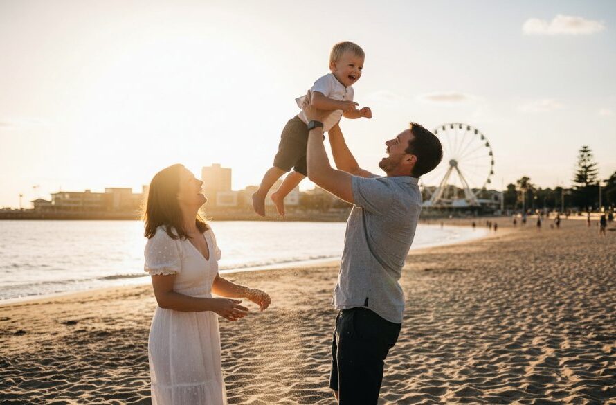 A heartwarming, candid photograph capturing a family's joyous laughter on Eastern Beach, Geelong, with the golden hour sun creating a dramatic flare, embodying unposed moments Geelong candid family photography at its best. The parents are playfully swinging their child, faces full of genuine happiness against the stunning coastal backdrop.