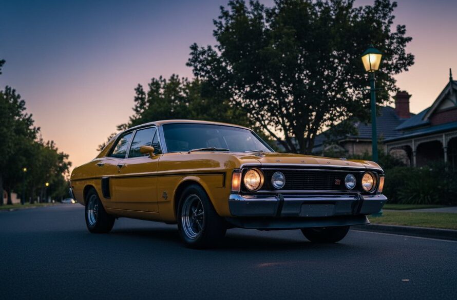 A powerful vintage car photoshoot in Drumcondra, Victoria, featuring a gleaming classic muscle car dramatically parked at dawn on a tree-lined street, with golden light reflecting off its polished chrome, evoking a sense of timeless power and elegance.