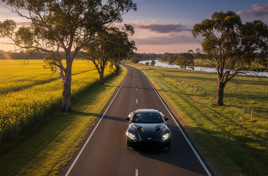 A stunning aerial view of a sleek, dark luxury sports car driving along a winding country road near Wangaratta at sunset, showcasing the vibrant rural landscapes, captured with dramatic lighting for an epic Wangaratta luxury vehicle photography rural landscapes portfolio shot.