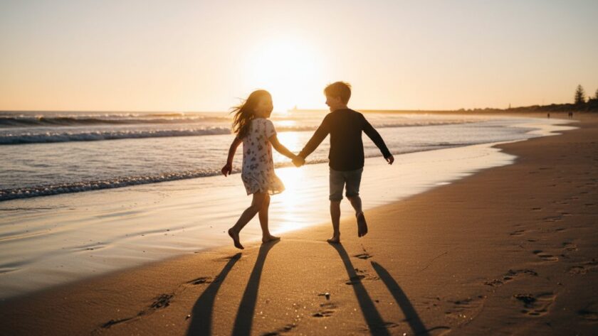 A wide-angle, low-angle professional photograph capturing Warrnambool kids photography epic moments capturing joy, showing two children joyfully running along the sandy shores of Warrnambool Beach at sunset, with dramatic golden light, crashing waves, and the iconic breakwater in the distance, evoking genuine happiness.