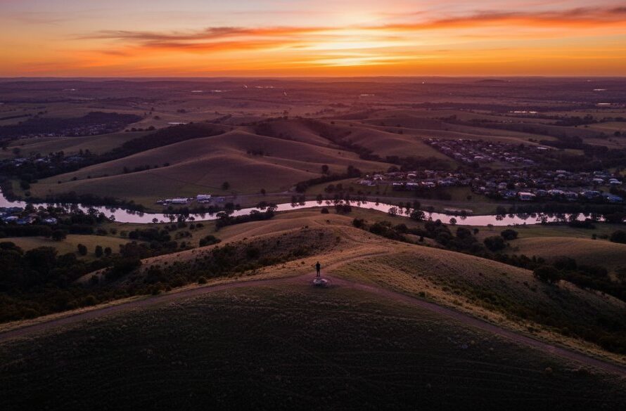 An epic moment captured by Waurn Ponds aerial photography for breathtaking Victorian landscapes, showcasing the vibrant colours of a sunset over the undulating hills of Waurn Ponds, with the Barwon River winding through, highlighting the serene beauty and vastness of the area.