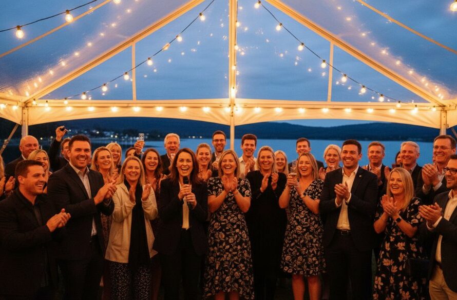 An emotional and vibrant photograph of guests laughing and cheering at an outdoor Wodonga event, perfectly showcasing Wodonga event photography capturing genuine joy, with golden hour light illuminating their faces and the natural beauty of the regional backdrop.