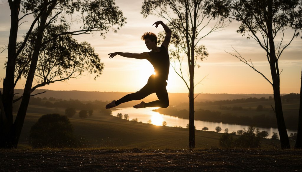 An epic moment captured in Wonga Park contemporary dance photography artistry, featuring a dancer mid-air in a dramatic leap against the soft, golden light of a Wonga Park sunset, evoking power and grace.
