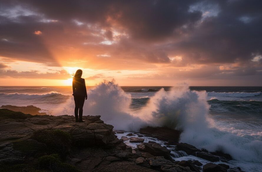 Dramatic Wonthaggi fine art photography capturing coastal moods with a lone figure silhouetted against a stormy sunset over Bass Strait, waves crashing, evoking deep emotion.