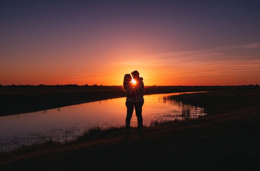A dramatic wide shot showcasing a family's tender embrace at sunset near Skeleton Creek in Wyndham Vale, Victoria, bathed in golden light, embodying the essence of Wyndham Vale Victoria Fine Art Storytelling Photography with a cinematic, emotive feel.
